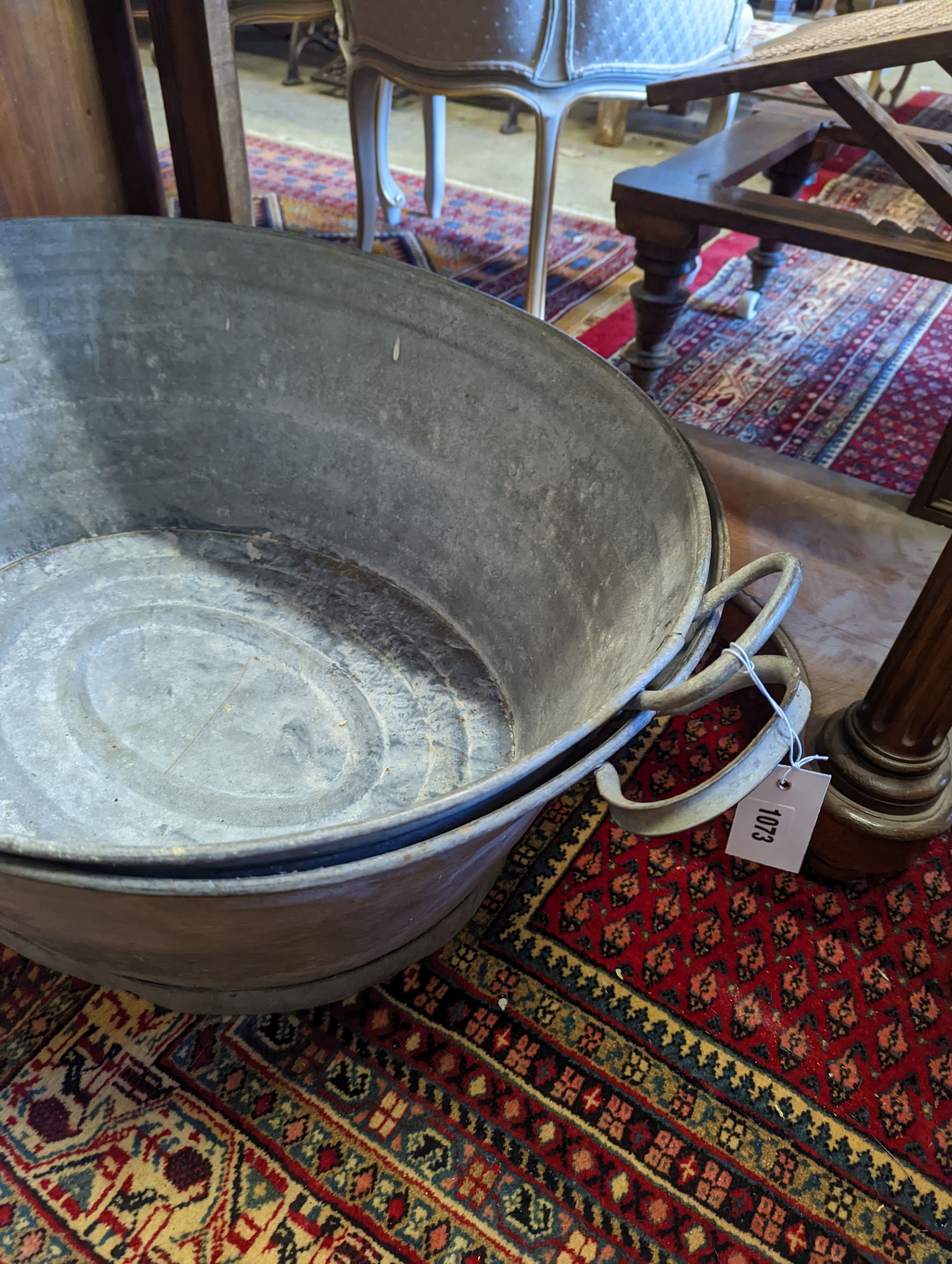 Two large oval galvanised tubs, larger width 89cm